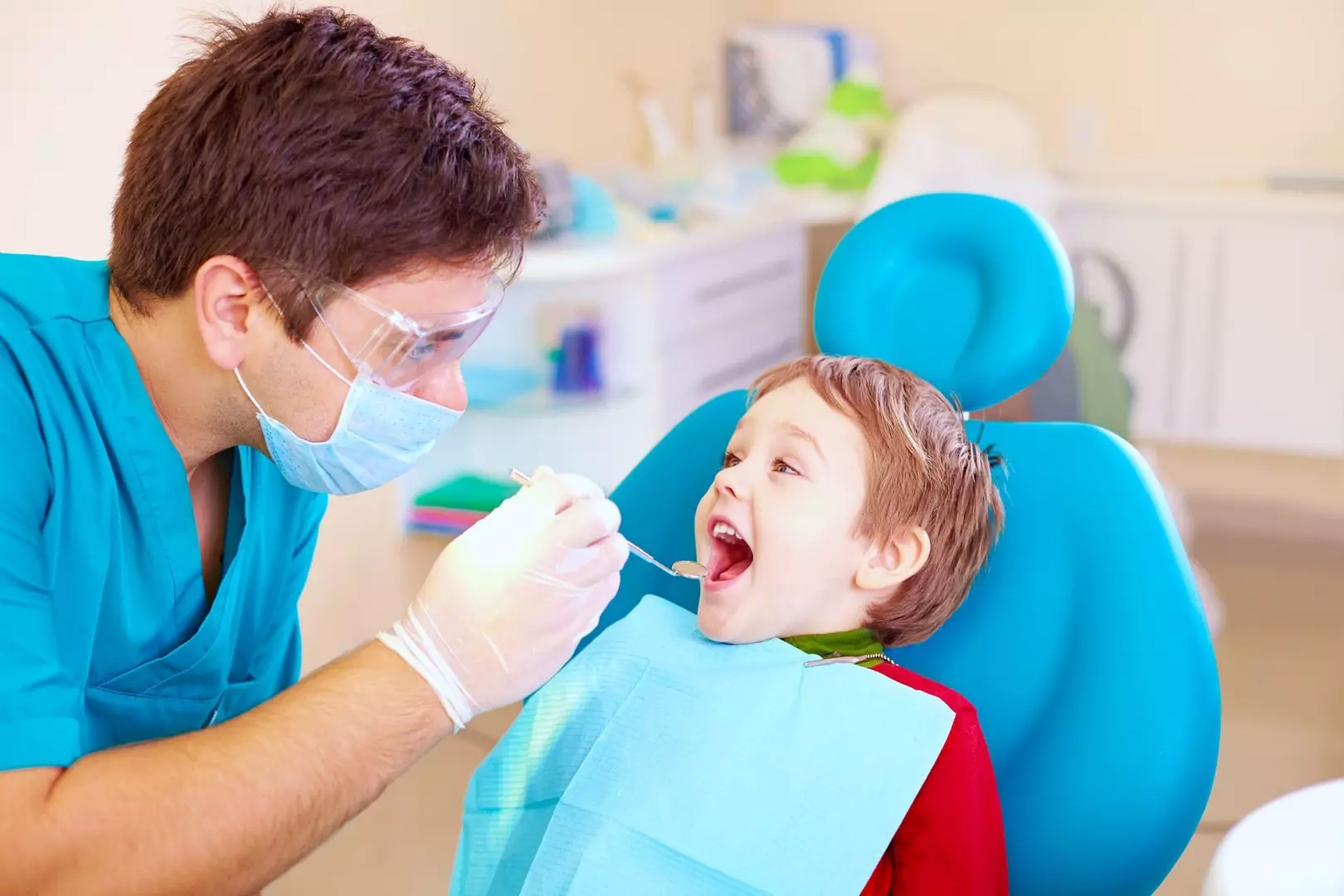 Dentiste avec enfant sur fauteuil